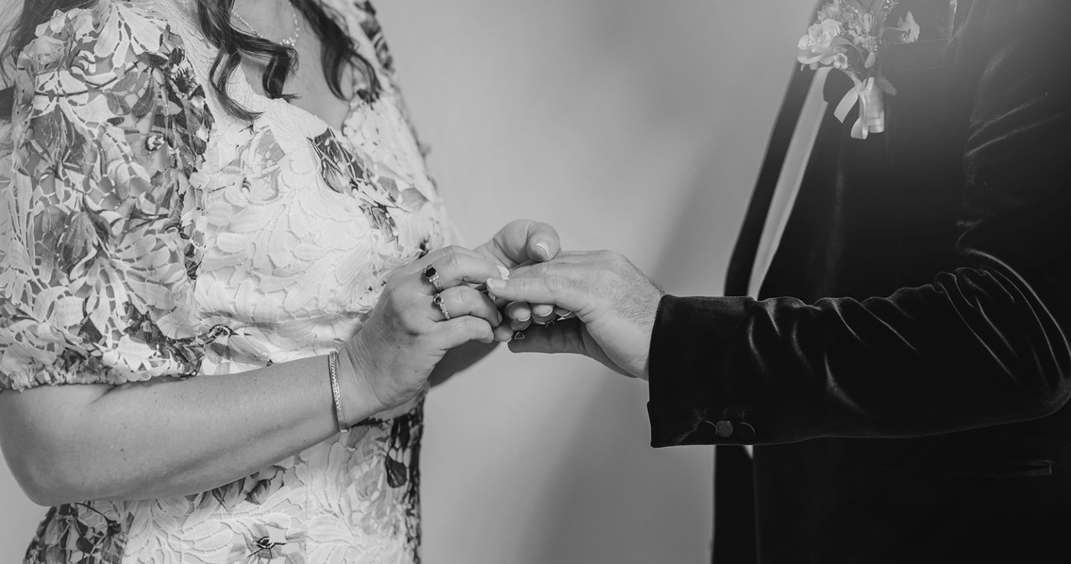 sa marriage office wedding – melissa & kyran 201 Bride and groom exchanging wedding rings during intimate black-and-white ceremony.