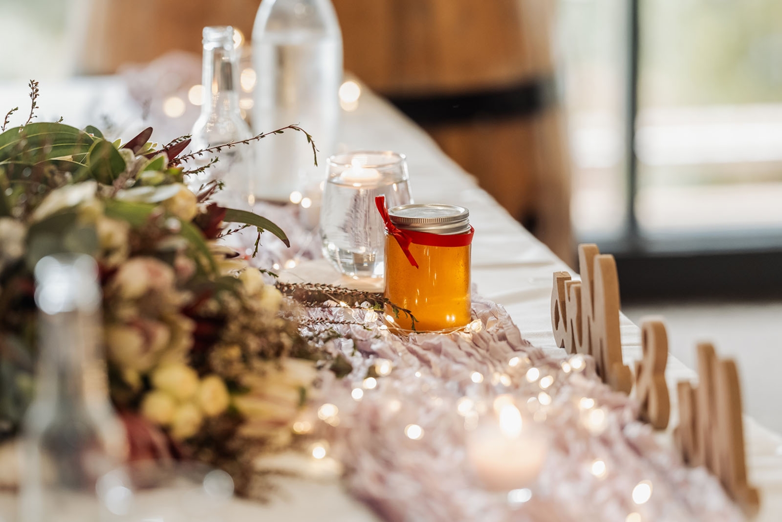 loxton's st peter's church wedding - madeline & brayden 66 Wedding table with honey jar favor, blush runner, fairy lights, and floral centerpiece.