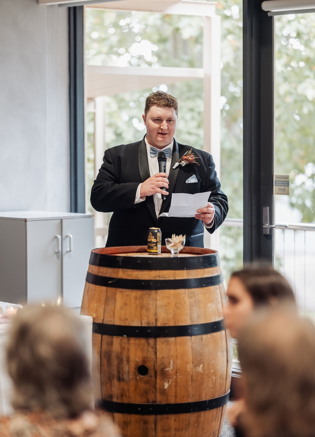 loxton's st peter's church wedding - madeline & brayden 64 Groomsman giving wedding toast at rustic barrel podium during elegant reception.
