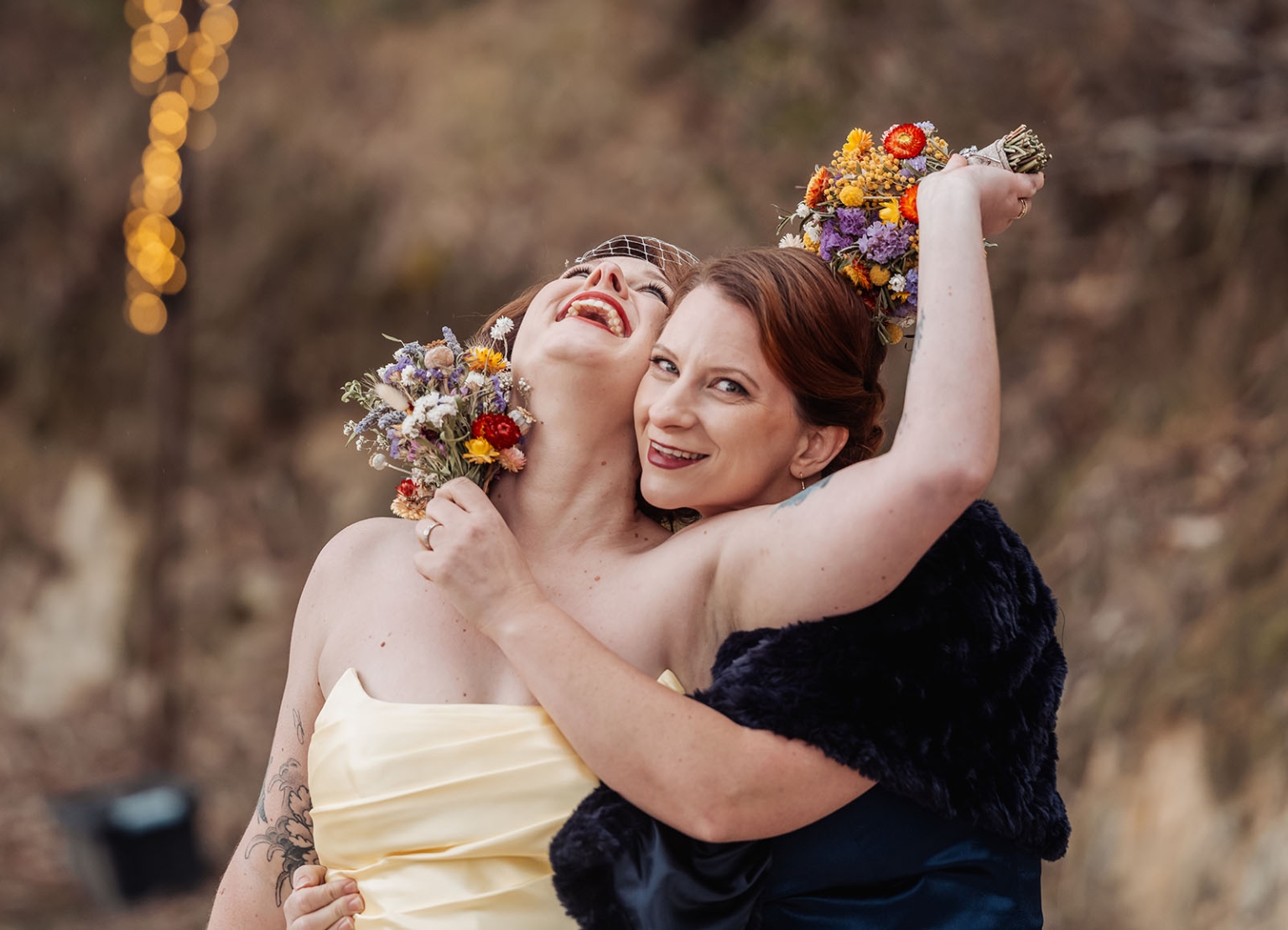 tiny house on the prairie wedding - lauren & bek 46 Joyful brides embracing with colorful wildflower wedding bouquets outdoors.