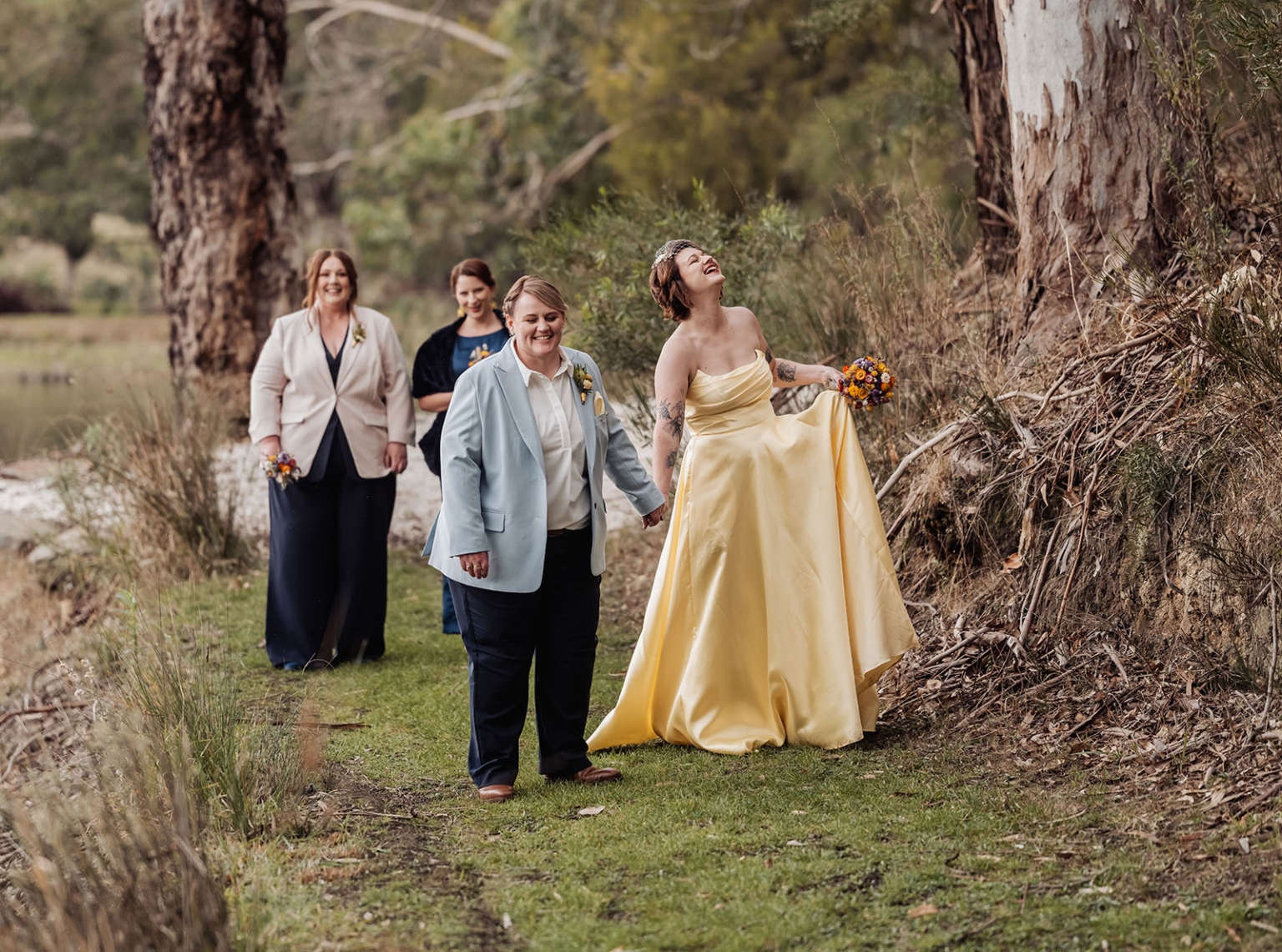 tiny house on the prairie wedding - lauren & bek 47 Joyful woodland wedding couple walking hand in hand with bridal party.