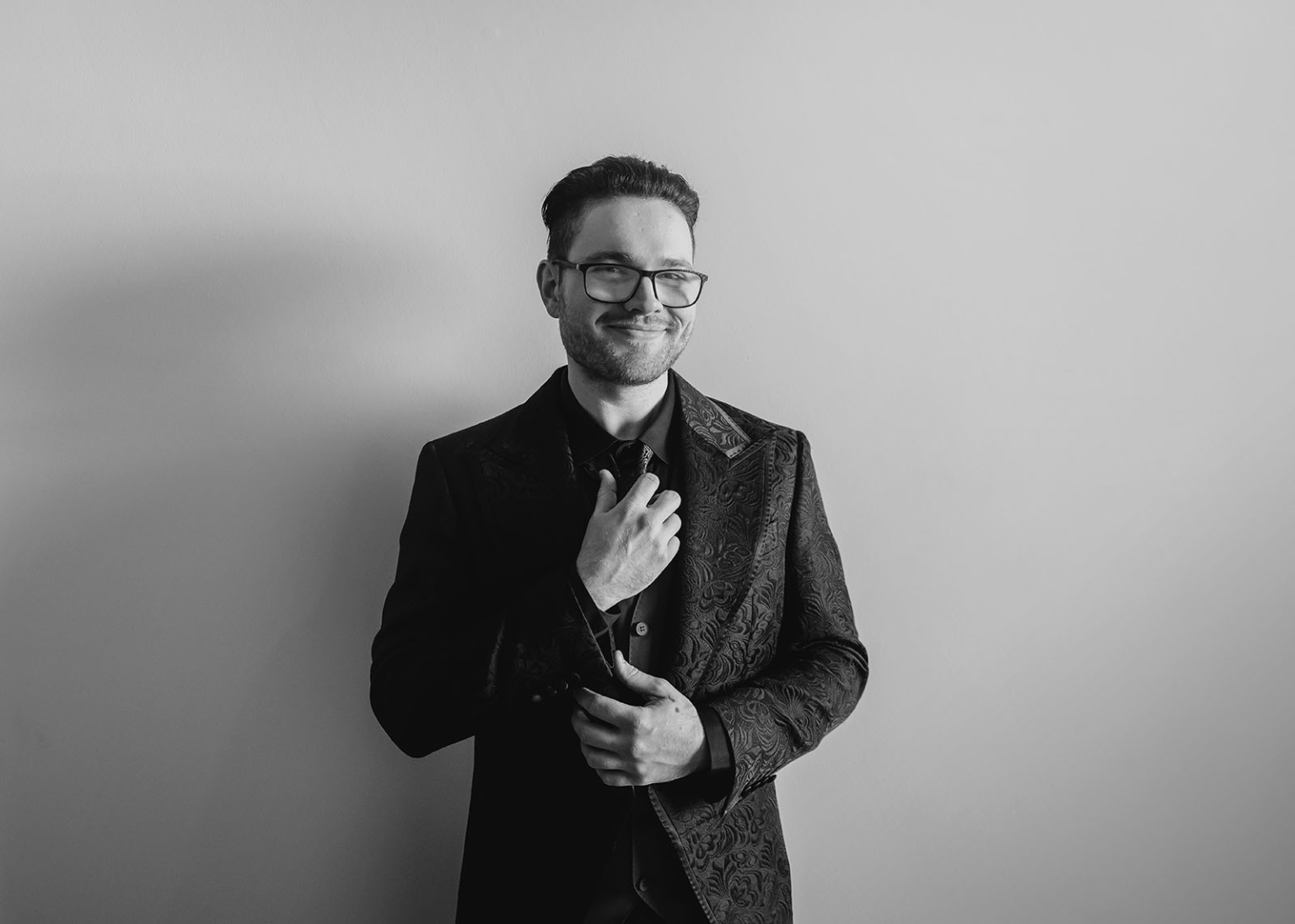 kuitpo hall wedding - courtney & jarrod 199 Black-and-white formal portrait of a stylish man in a patterned suit.