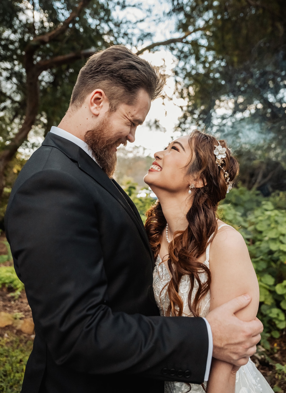 wedding at al-ru farm – teresa & thomas 29 Bride and groom sharing a joyful wedding portrait in a sunlit garden.