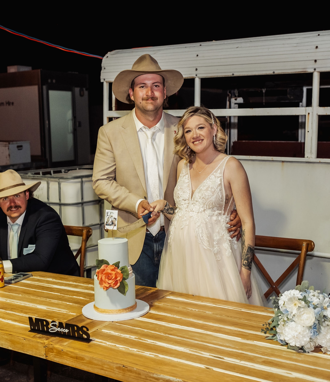 capella wedding photography – caitlin & adam’s farm wedding 186 Caitlin and Adam cutting their wedding cake at their Capella farm wedding, with a vintage truck behind them