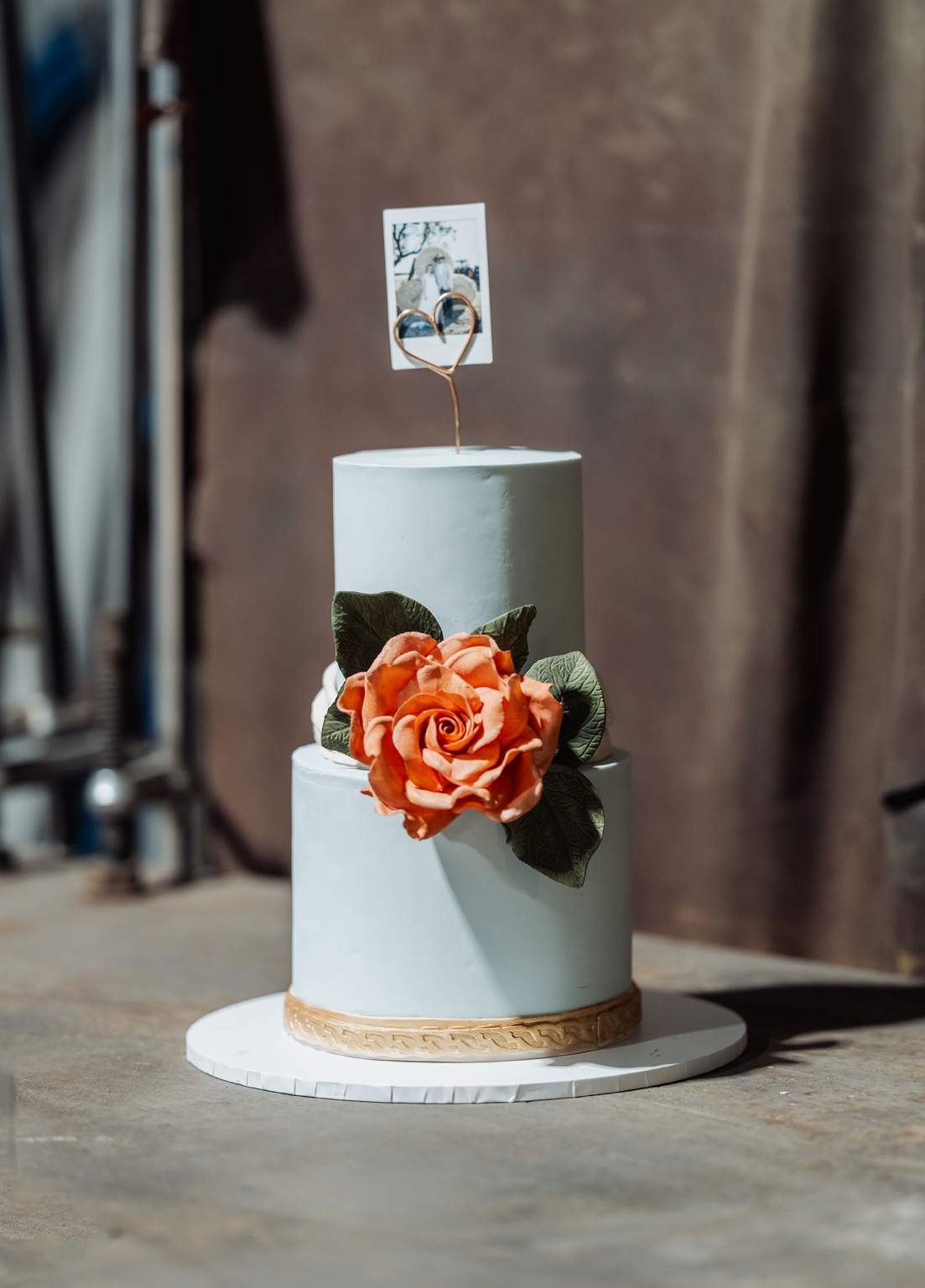 capella wedding photography – caitlin & adam’s farm wedding 180 Two-tier pale blue wedding cake decorated with an orange sugar rose, green leaves and a heart-shaped photo topper at Caitlin and Adam’s farm wedding