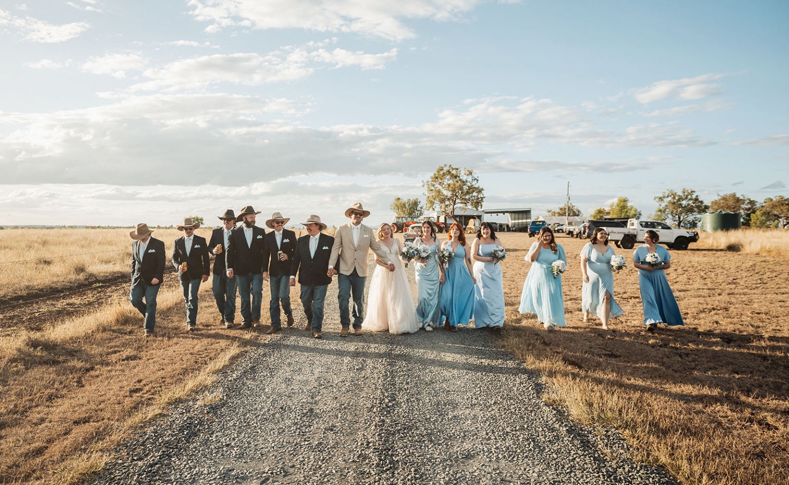 capella wedding photography – caitlin & adam’s farm wedding 158 Caitlin and Adam walking with their wedding party along a gravel track at their Capella farm wedding