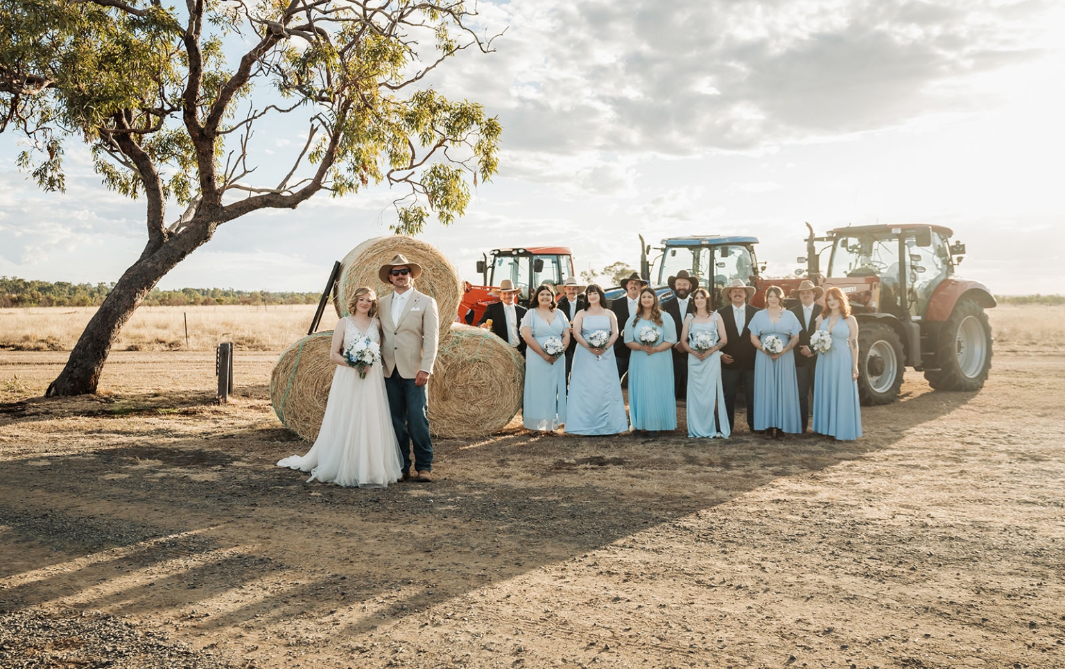 capella wedding photography – caitlin & adam’s farm wedding 154 Caitlin and Adam with their wedding party beside hay bales and tractors at their Capella farm wedding