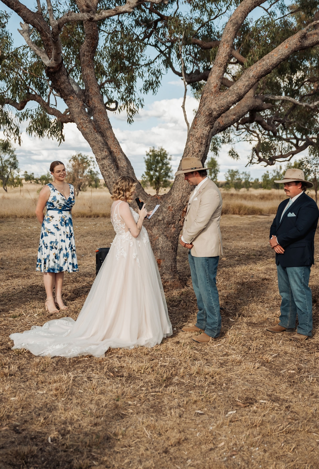 capella wedding photography – caitlin & adam’s farm wedding 146 Bride reading her vows to the groom beneath a large gum tree during a farm wedding in Capella