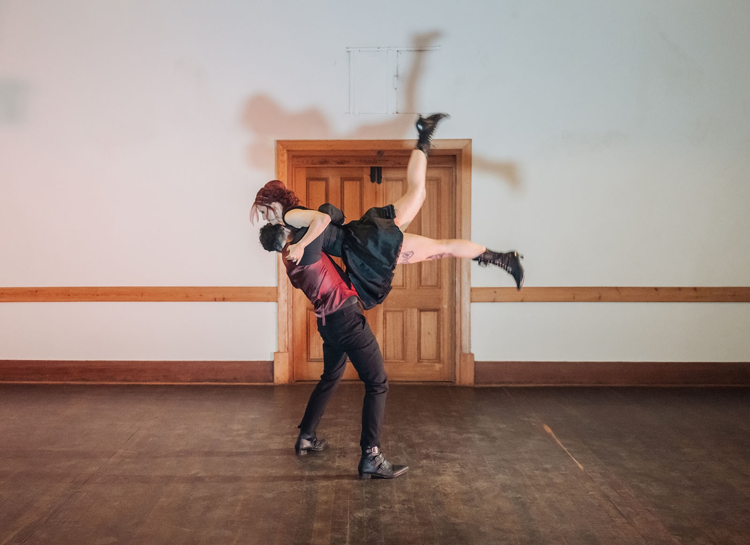 kuitpo hall wedding - courtney & jarrod 253 Contemporary dancers perform dramatic lift in rehearsal hall with wooden floor.