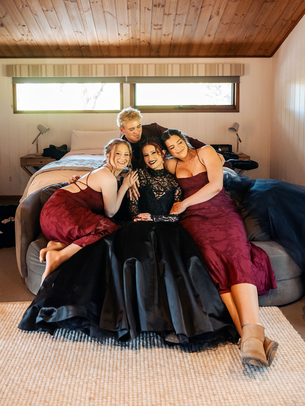 kuitpo hall wedding - courtney & jarrod 207 Formal friends bedroom portrait in black and burgundy dresses on cozy bed.