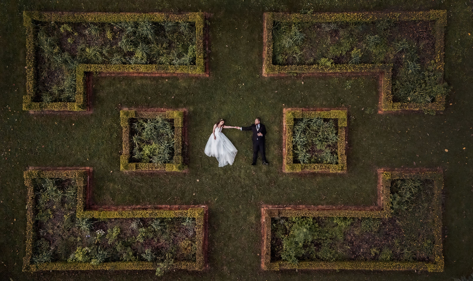 wedding at al-ru farm – teresa & thomas 35 Overhead wedding portrait of bride and groom holding hands in a formal garden.