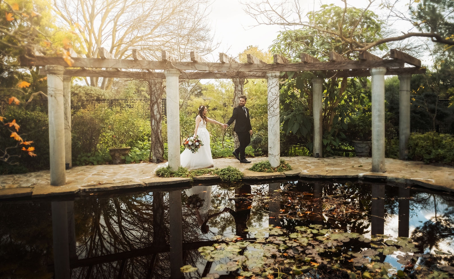 wedding at al-ru farm – teresa & thomas 37 Bride and groom at romantic garden wedding under rustic pergola by reflective pond.