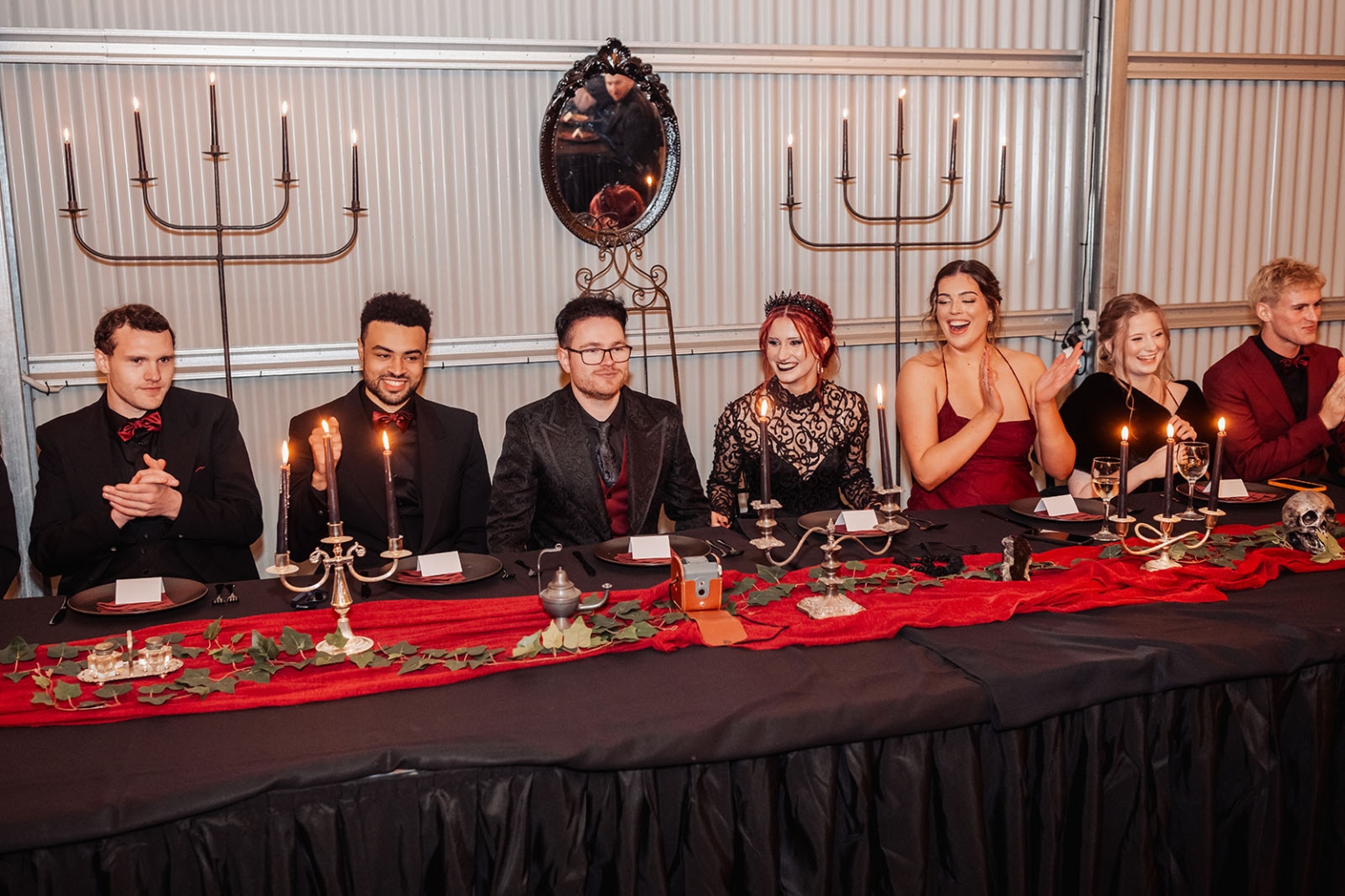 kuitpo hall wedding - courtney & jarrod 258 Gothic candlelit banquet table with formal guests, red accents, skull decor, and candelabras.