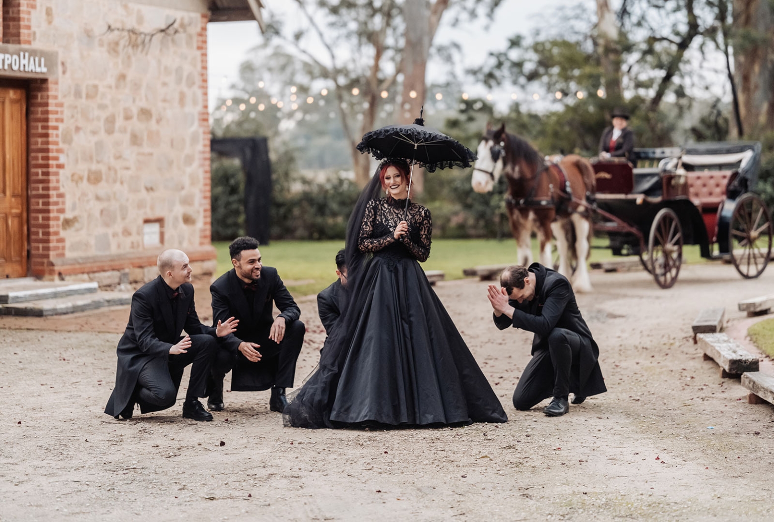 kuitpo hall wedding - courtney & jarrod 235 Gothic black bride poses with groomsmen and horse-drawn carriage at vintage wedding.
