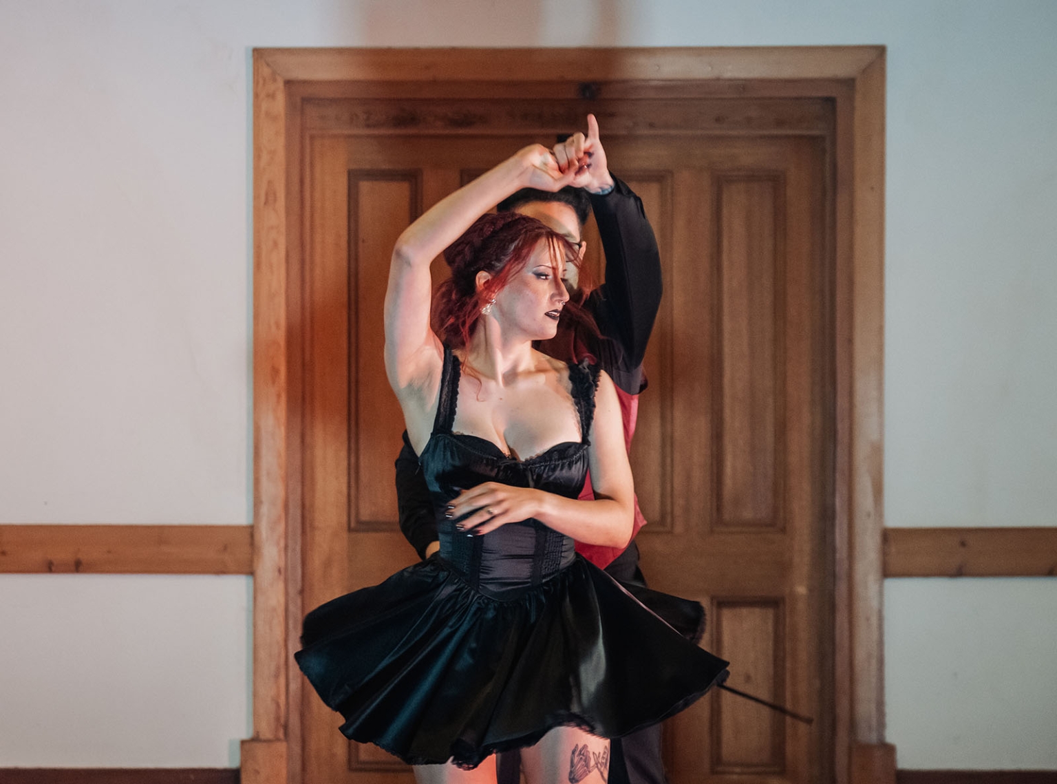 kuitpo hall wedding - courtney & jarrod 255 Gothic dance performance with red-haired woman in black costume before wooden doors.