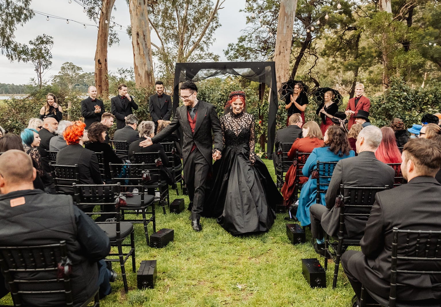 kuitpo hall wedding - courtney & jarrod 231 Gothic forest wedding ceremony with black dress, red accents, and outdoor aisle.