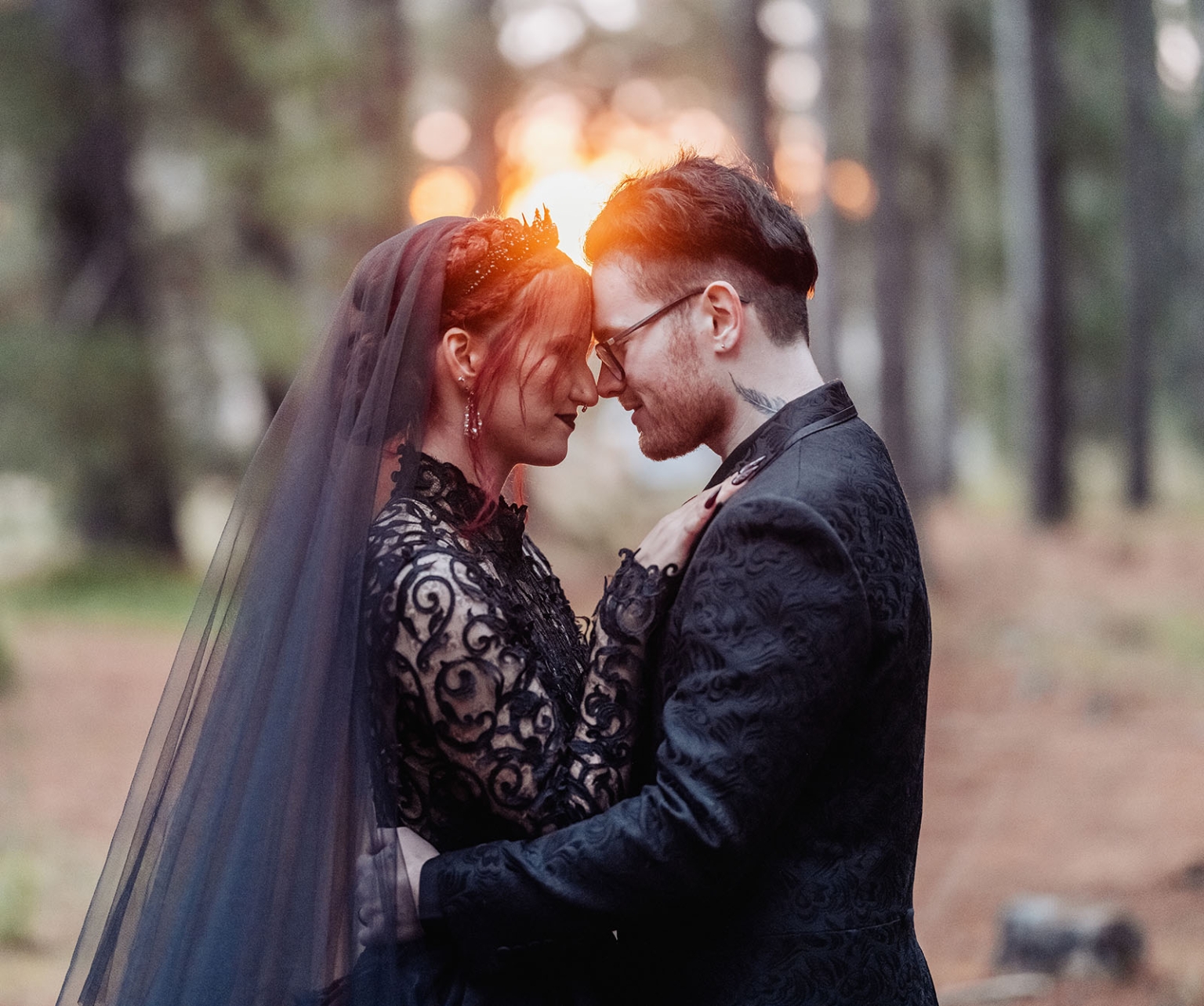kuitpo hall wedding - courtney & jarrod 247 Gothic wedding couple in black attire embracing in a sunset forest.