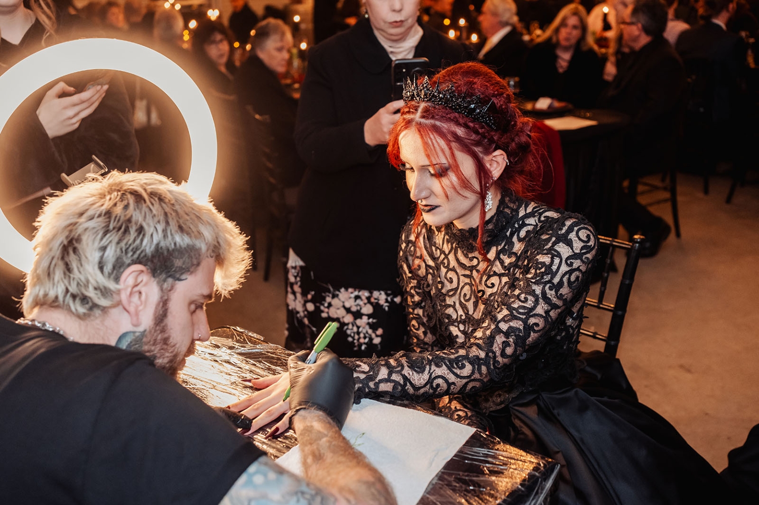 kuitpo hall wedding - courtney & jarrod 260 Gothic woman getting a tattoo at an elegant indoor event.