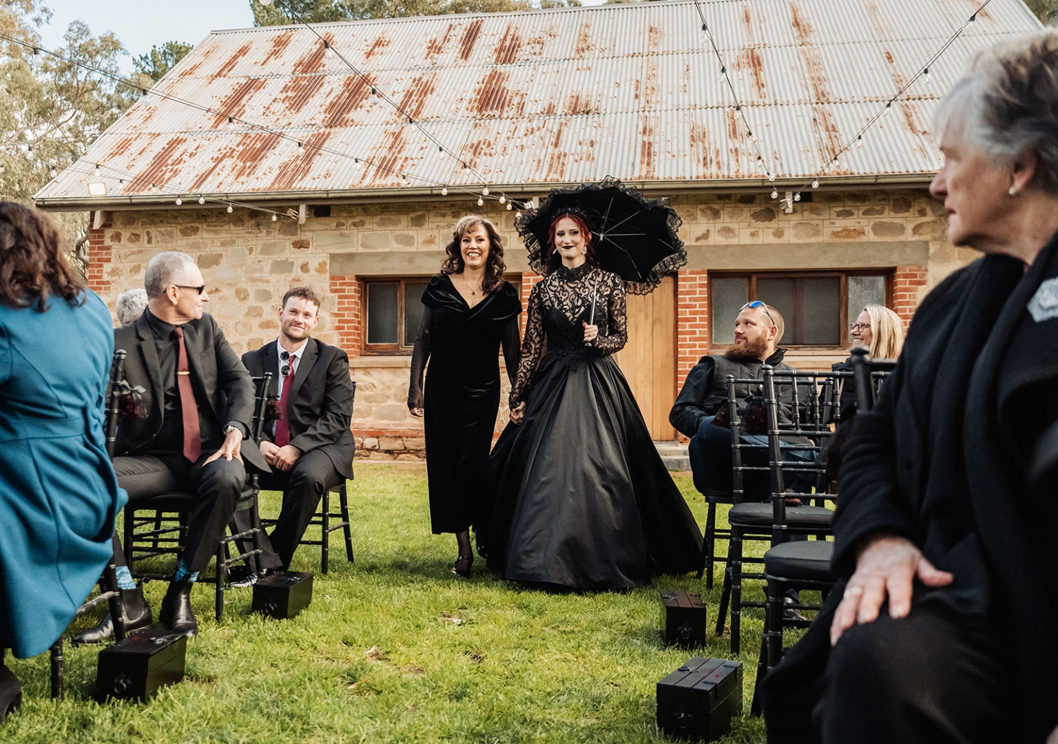 kuitpo hall wedding - courtney & jarrod 222 Gothic wedding procession at rustic stone venue with black bridal gown and parasol.