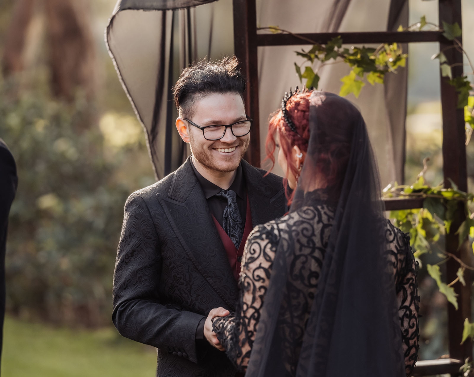 kuitpo hall wedding - courtney & jarrod 223 Gothic wedding ceremony with black lace bride and groom under woodland arch.