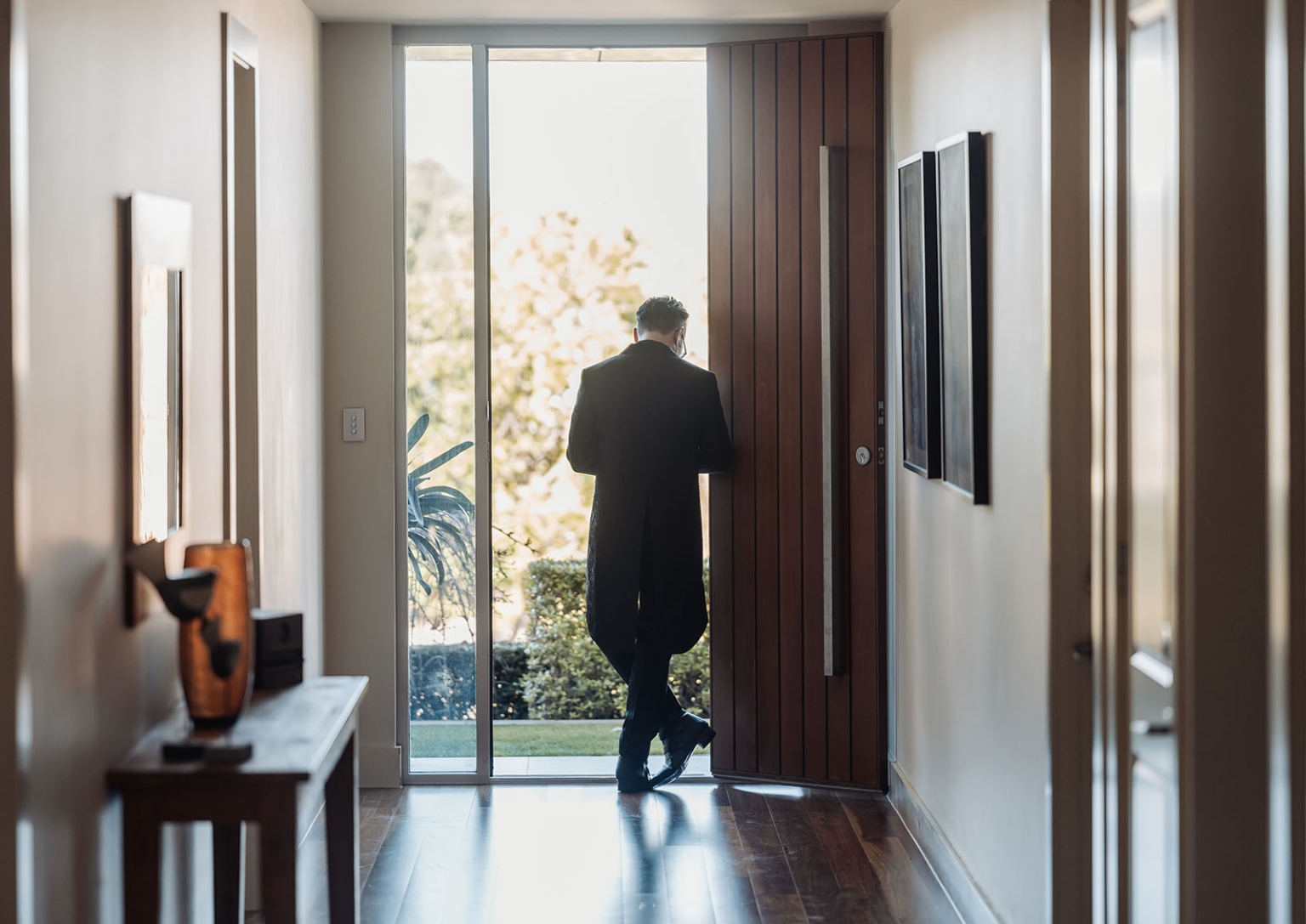 kuitpo hall wedding - courtney & jarrod 198 Modern entry hallway with open wood door and suited man at entrance.