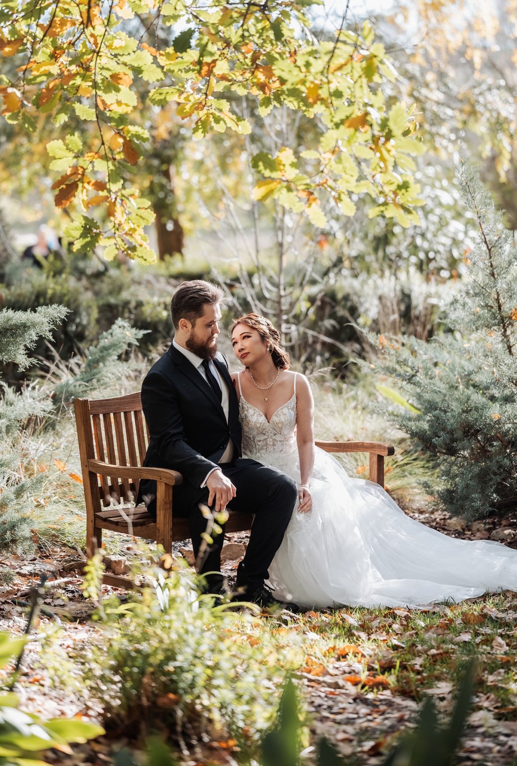 wedding at al-ru farm – teresa & thomas 7 Newlywed couple on garden bench in romantic outdoor wedding portrait.