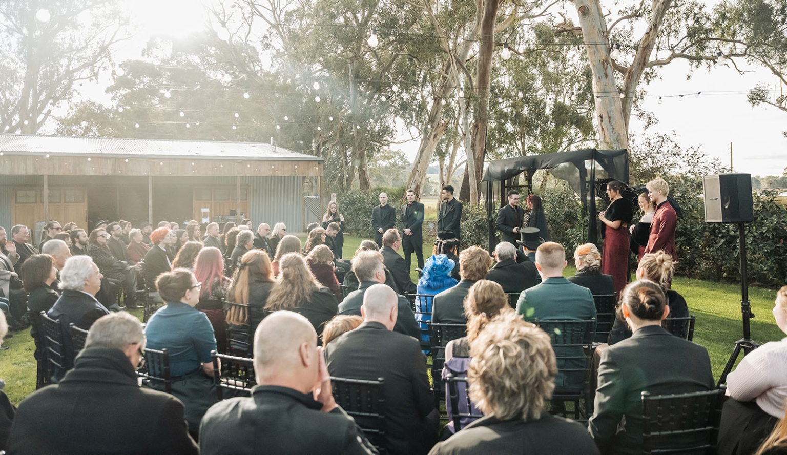 kuitpo hall wedding - courtney & jarrod 227 Gothic outdoor wedding ceremony with guests on lawn under eucalyptus trees.