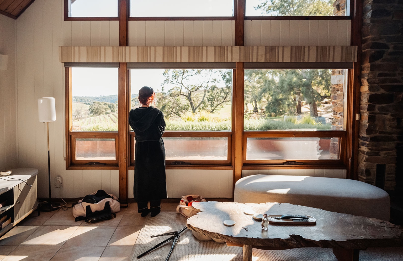 kuitpo hall wedding - courtney & jarrod 202 Sunlit rustic living room with countryside view through large wooden windows.