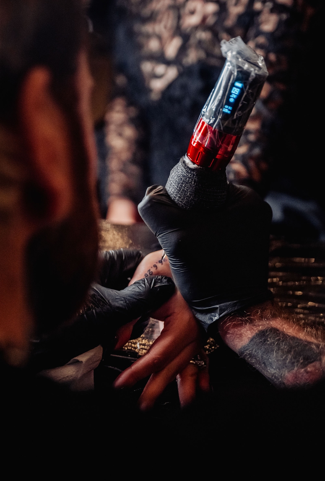 kuitpo hall wedding - courtney & jarrod 267 Tattoo artist using rotary tattoo machine on finger in close-up studio session.