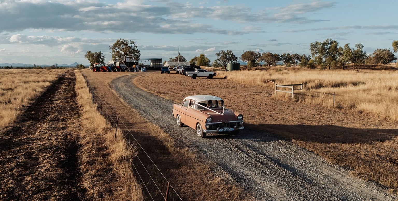 capella wedding photography – caitlin & adam’s farm wedding 157 Vintage wedding car with white ribbon on a gravel driveway at a Capella farm wedding