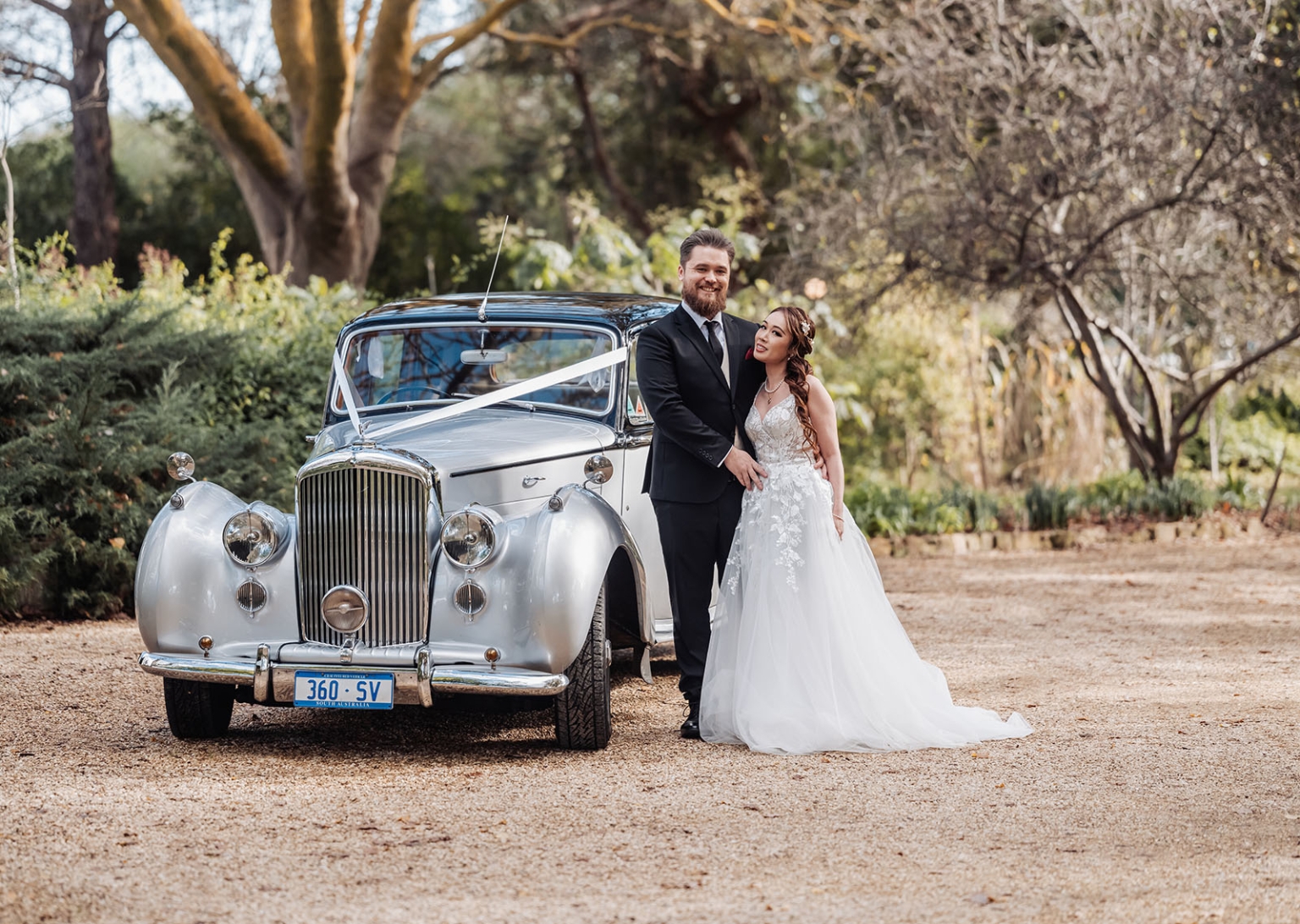wedding at al-ru farm – teresa & thomas 2 Bride and groom posing with silver vintage wedding car in rustic garden.