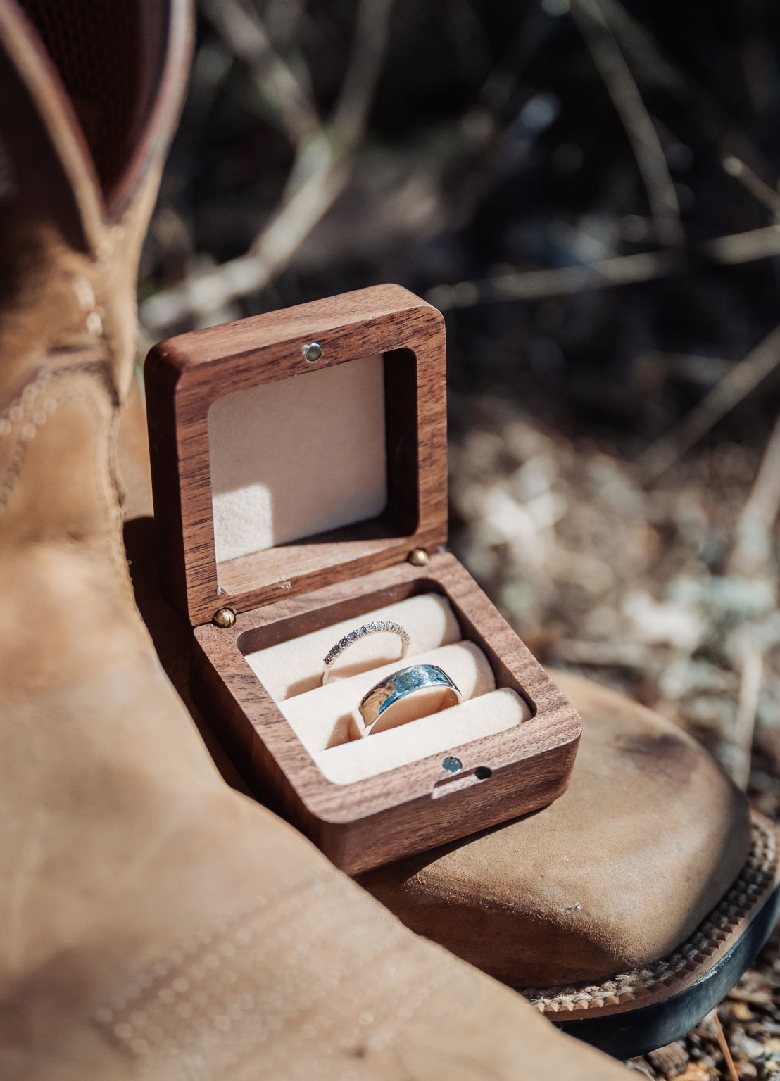 capella wedding photography – caitlin & adam’s farm wedding 113 Wedding rings in an open wooden ring box resting on tan leather boots