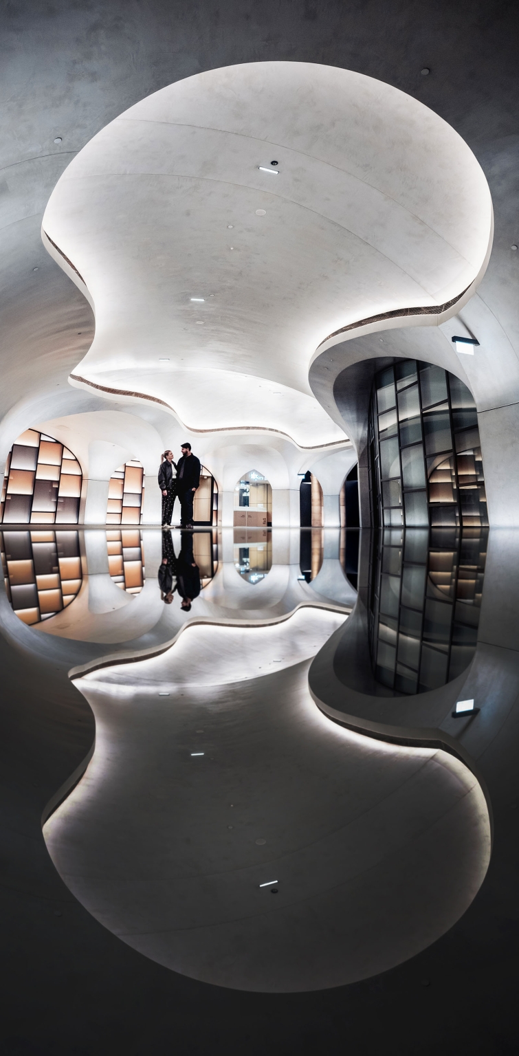 elder park rotunda proposal - lauren & enrique 17 Lauren and Enrique standing together in a sculptural modern interior, reflected in the glossy floor