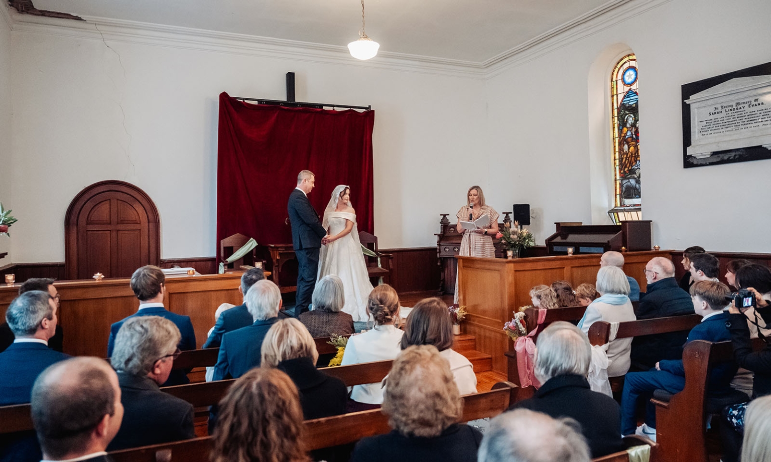 keyneton soldier's memorial hall wedding - lara & simon 11 Lara and Simon standing at the altar during their wedding ceremony as guests watch inside Keyneton Church.
