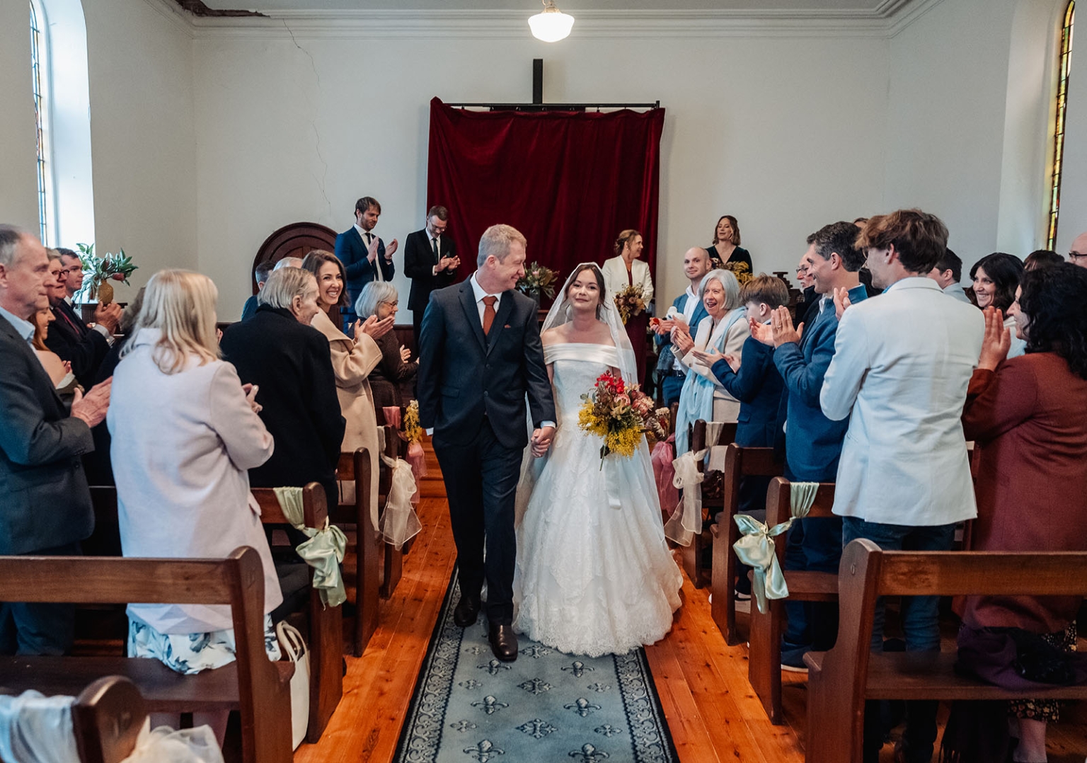 keyneton soldier's memorial hall wedding - lara & simon 15 Lara and Simon walk hand in hand down the church aisle as wedding guests applaud