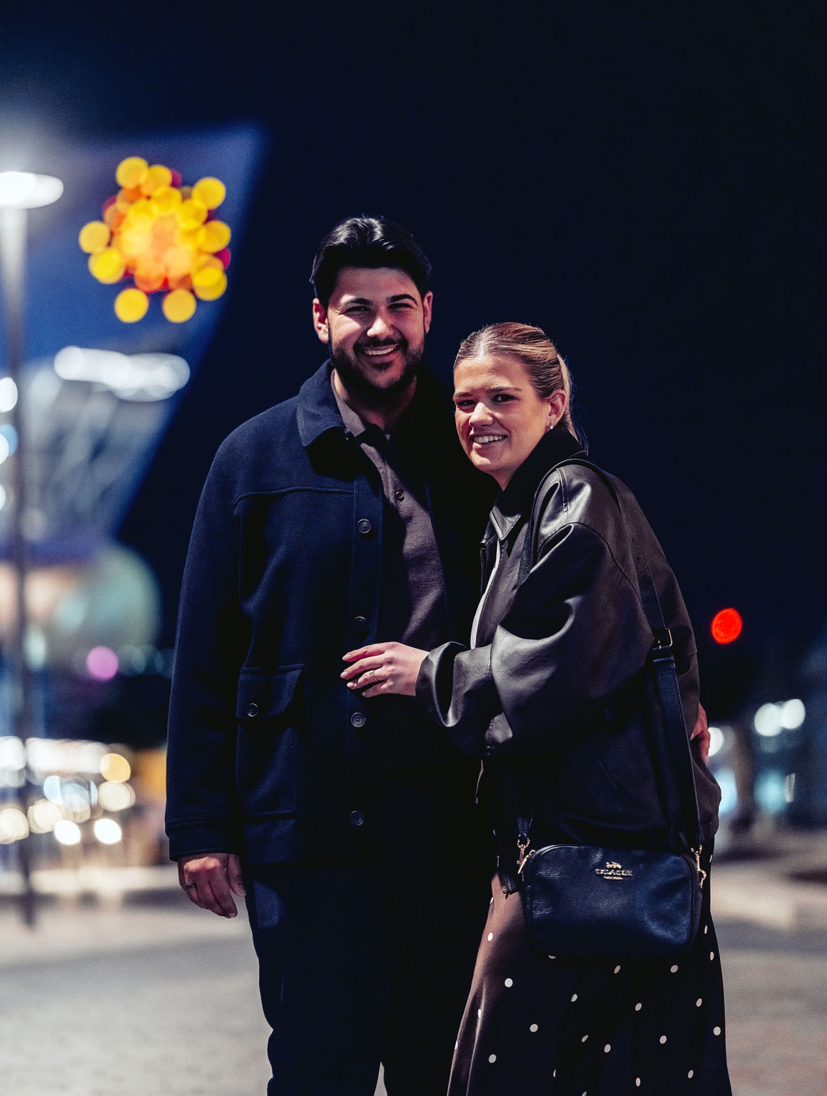 elder park rotunda proposal - lauren & enrique 20 Lauren and Enrique smiling together at night near Elder Park, with blurred city lights behind them