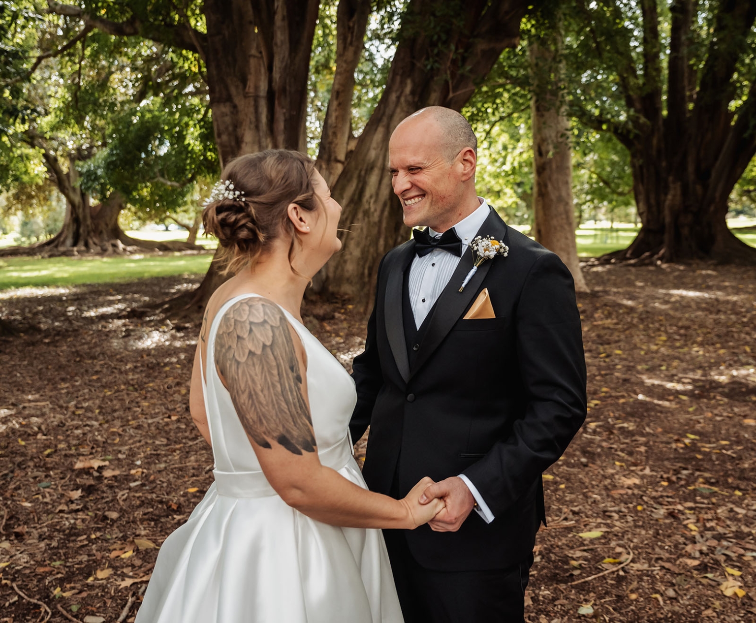 marriage registration office wedding - mia & roberto 53 Mia and Roberto holding hands and smiling beneath Moreton Bay fig trees in Adelaide Botanic Park