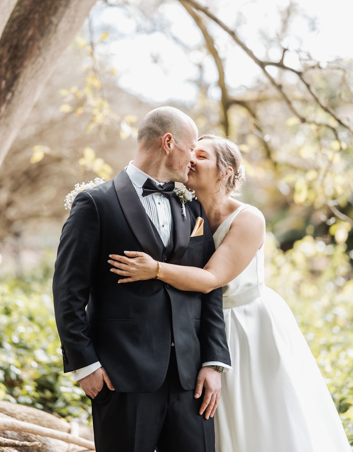 marriage registration office wedding - mia & roberto 63 Mia kisses Roberto on the cheek beneath a large tree in Adelaide Botanic Park