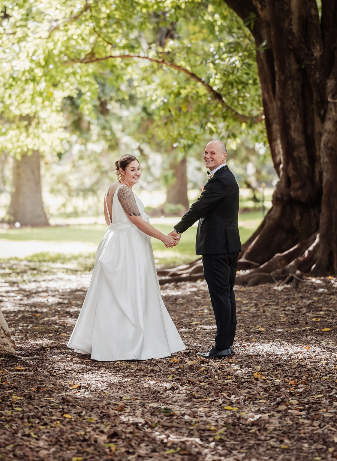 marriage registration office wedding - mia & roberto 56 Mia and Roberto holding hands beneath a large fig tree in Adelaide Botanic Park