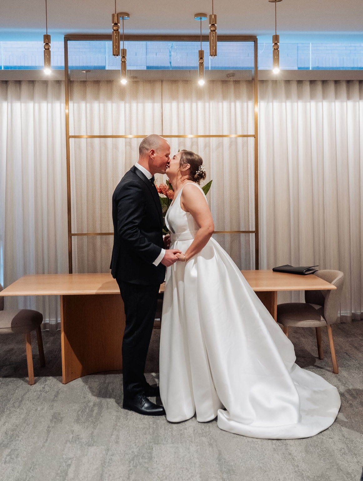 marriage registration office wedding - mia & roberto 91 Mia and Roberto kissing in a modern marriage registration office, the bride in a white gown and the groom in a dark suit