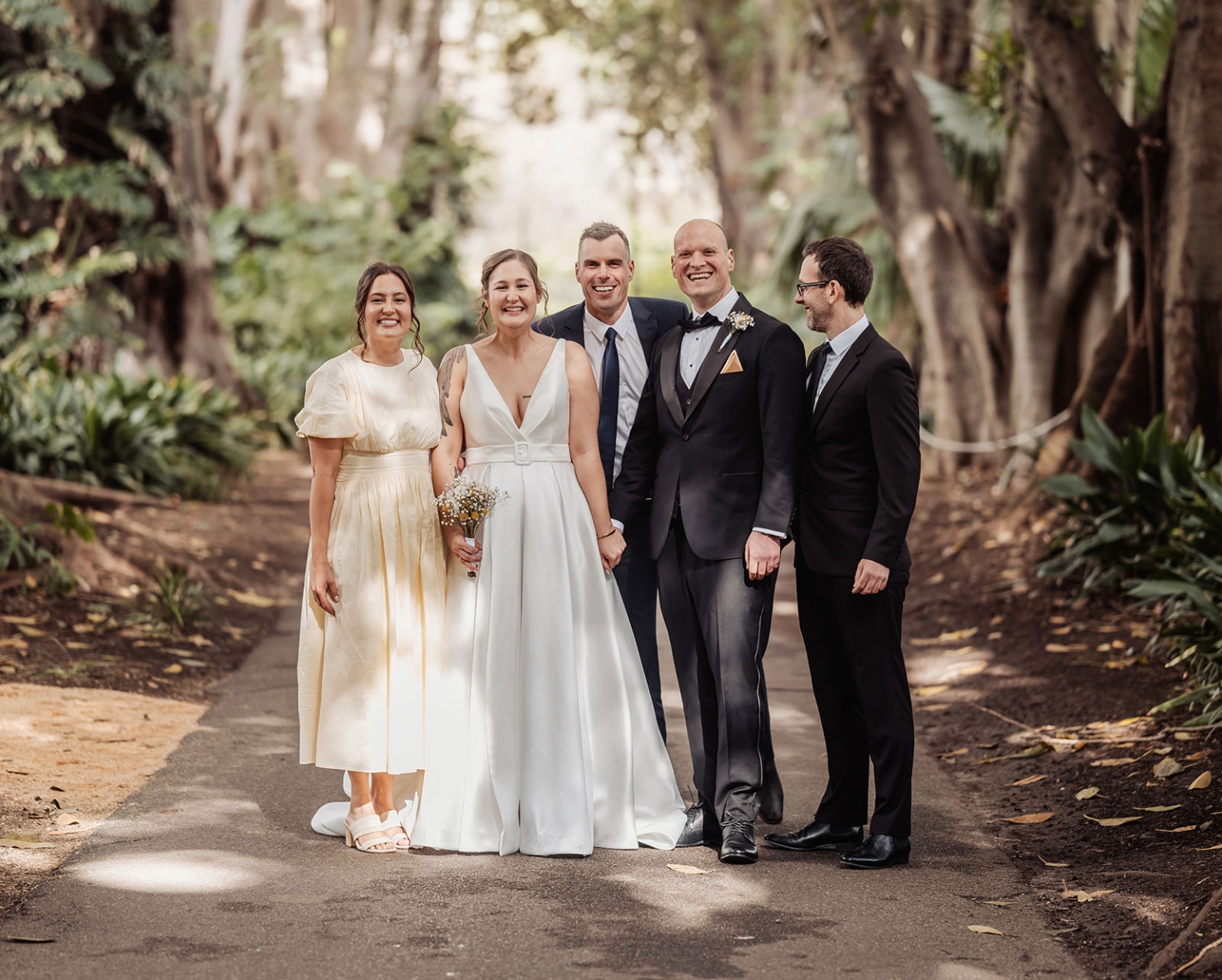 marriage registration office wedding - mia & roberto 62 Mia and Roberto smiling with three wedding party members on a tree-lined path in Adelaide Botanic Park