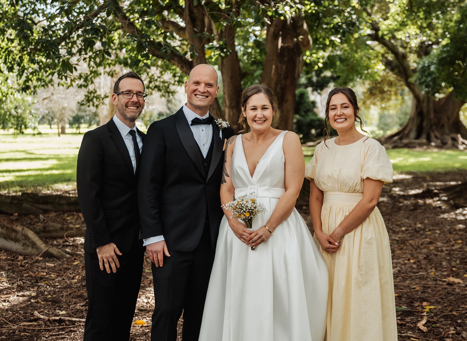 marriage registration office wedding - mia & roberto 58 Mia and Roberto standing with two wedding party members beneath large trees in Adelaide Botanic Park