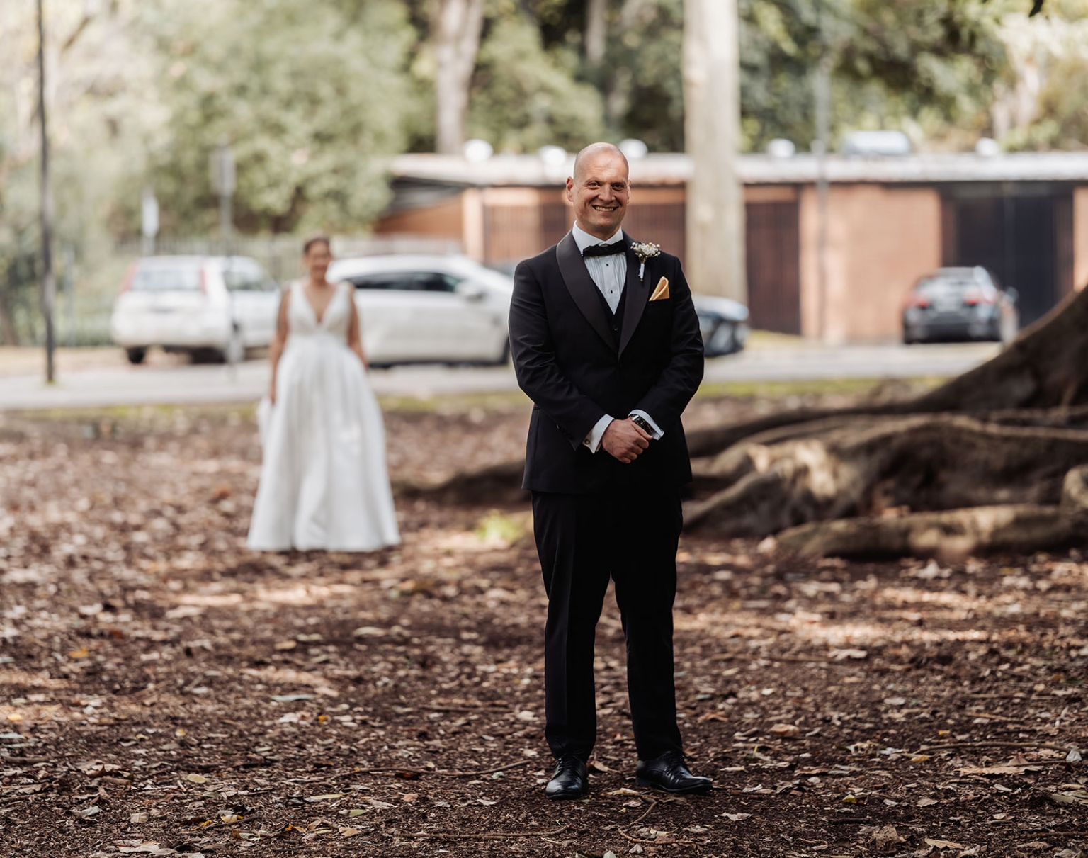 marriage registration office wedding - mia & roberto 50 Roberto smiling in a black tuxedo as Mia approaches in her wedding dress for their first look at Adelaide Botanic Park