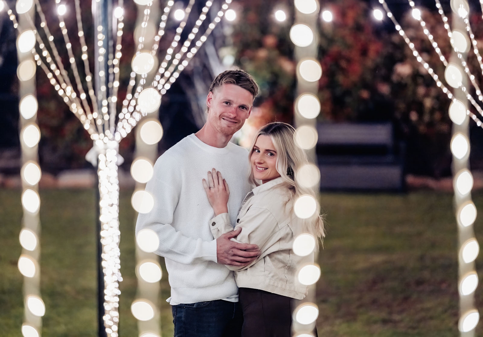 tiny house on the prairie proposal - kyle & bianca 16 Kyle and Bianca embracing beneath a canopy of glowing fairy lights, with Bianca's engagement ring visible