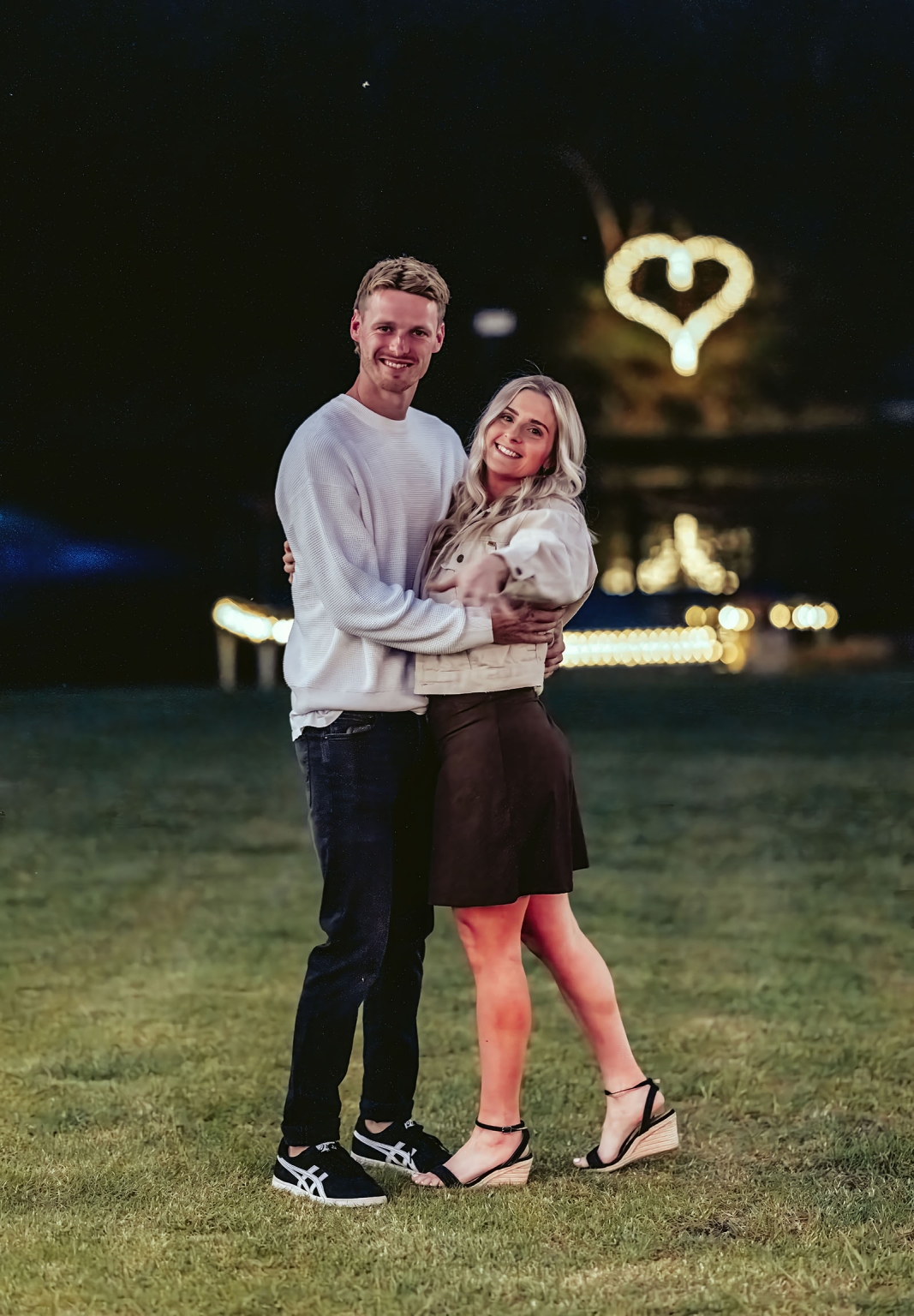 tiny house on the prairie proposal - kyle & bianca 9 Kyle and Bianca embracing on a lawn at night beneath glowing heart-shaped lights