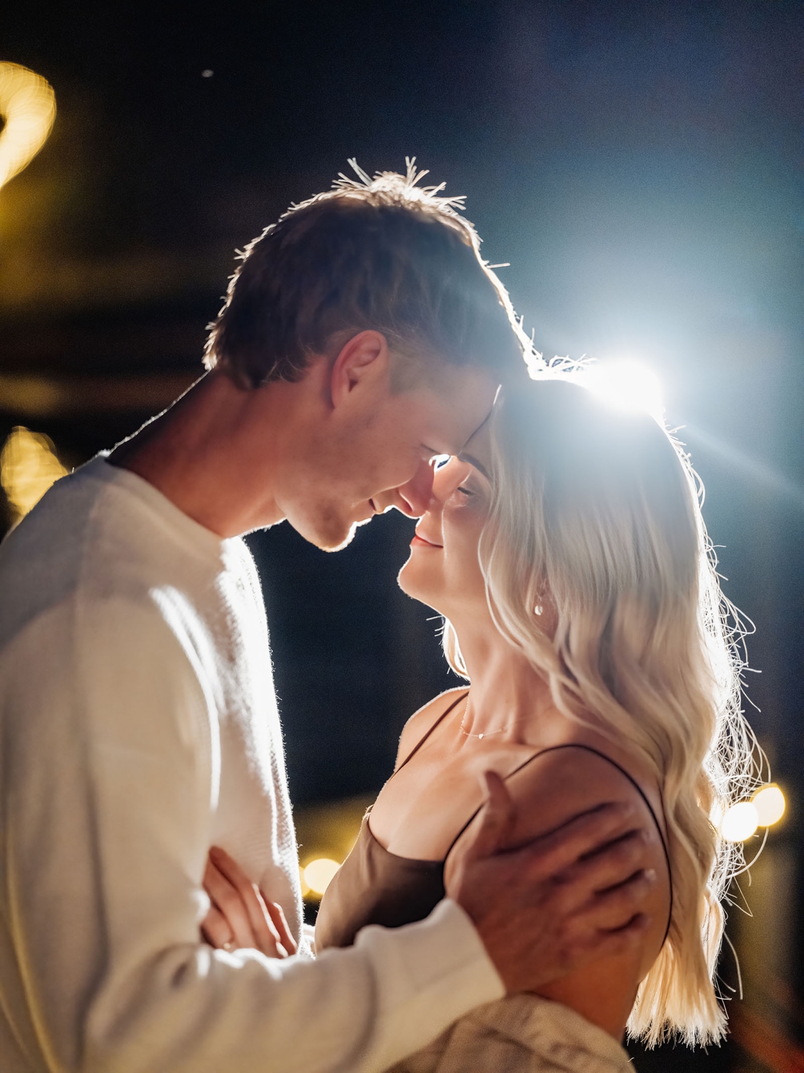 tiny house on the prairie proposal - kyle & bianca 20 Kyle and Bianca embracing beneath warm fairy lights at night