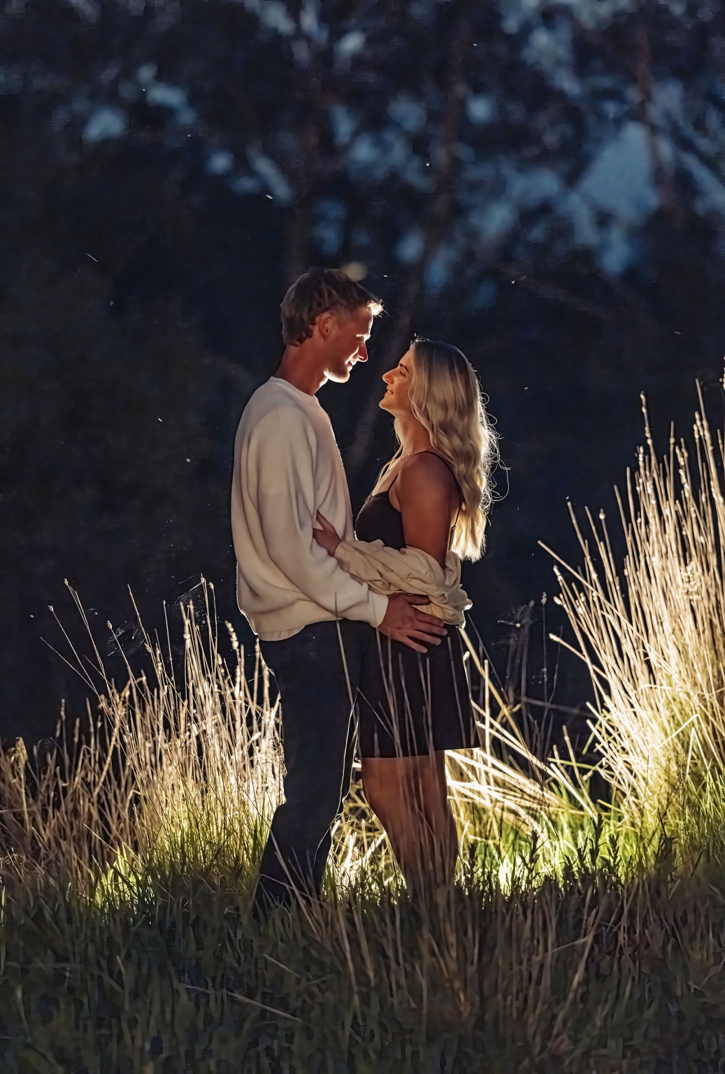 tiny house on the prairie proposal - kyle & bianca 19 Kyle and Bianca smiling at each other while standing among tall grass at dusk during their proposal at Tiny House on the Prairie
