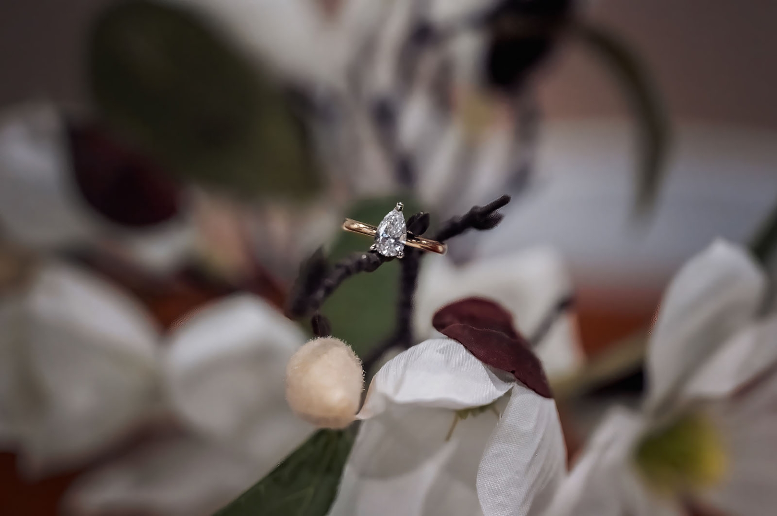 tiny house on the prairie proposal - kyle & bianca 21 Pear-cut diamond engagement ring resting among white and burgundy flowers