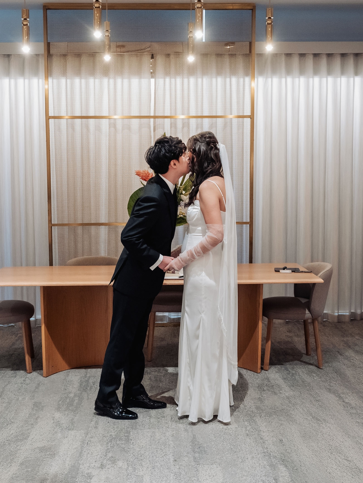 marriage rego office wedding – teri & thomas 8 Teri and Thomas kissing while holding hands at the Adelaide Marriage and Registration Office wedding ceremony