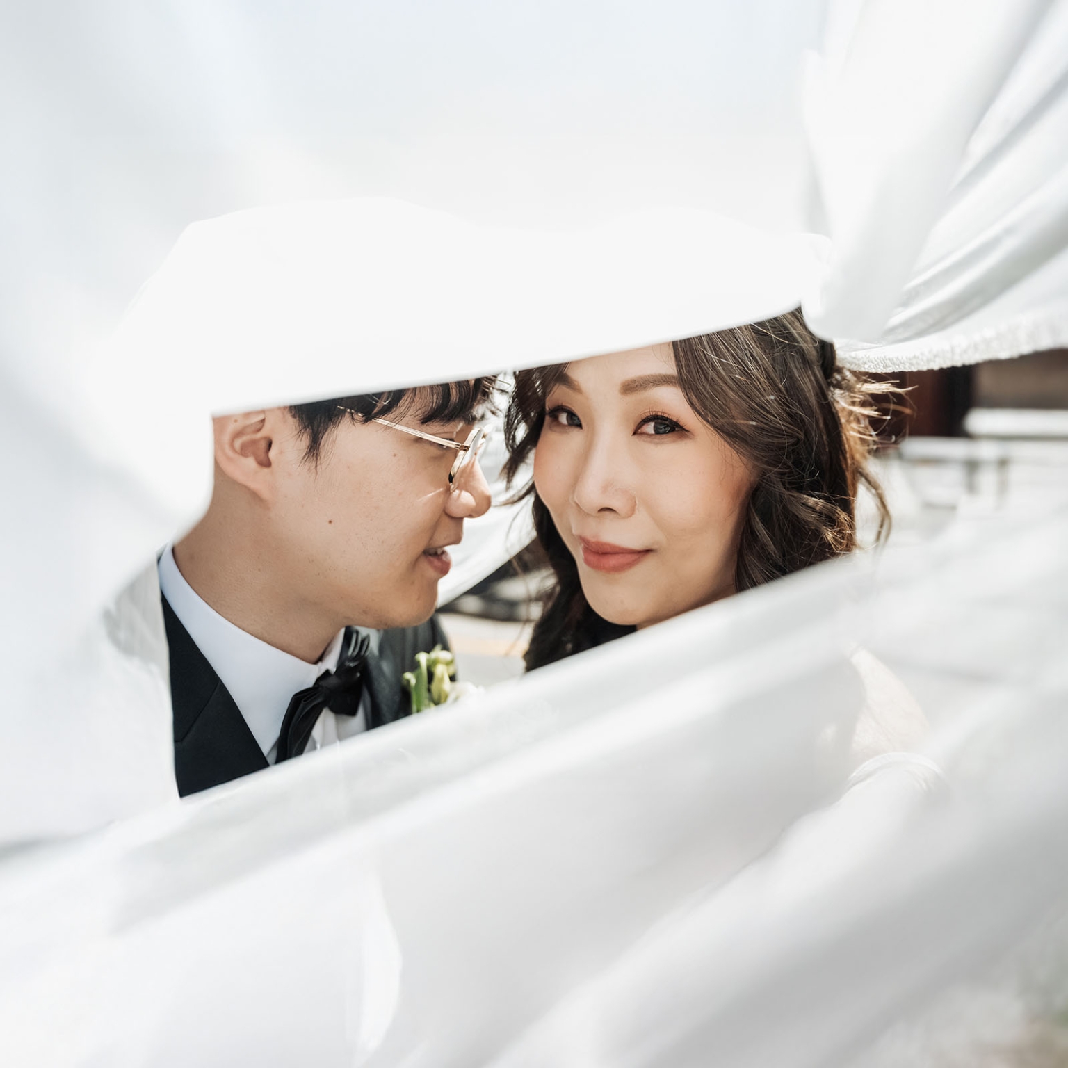 marriage rego office wedding – teri & thomas 15 Teri and Thomas framed by Teri’s white wedding veil, with Thomas in a black tuxedo and Teri looking towards the camera.